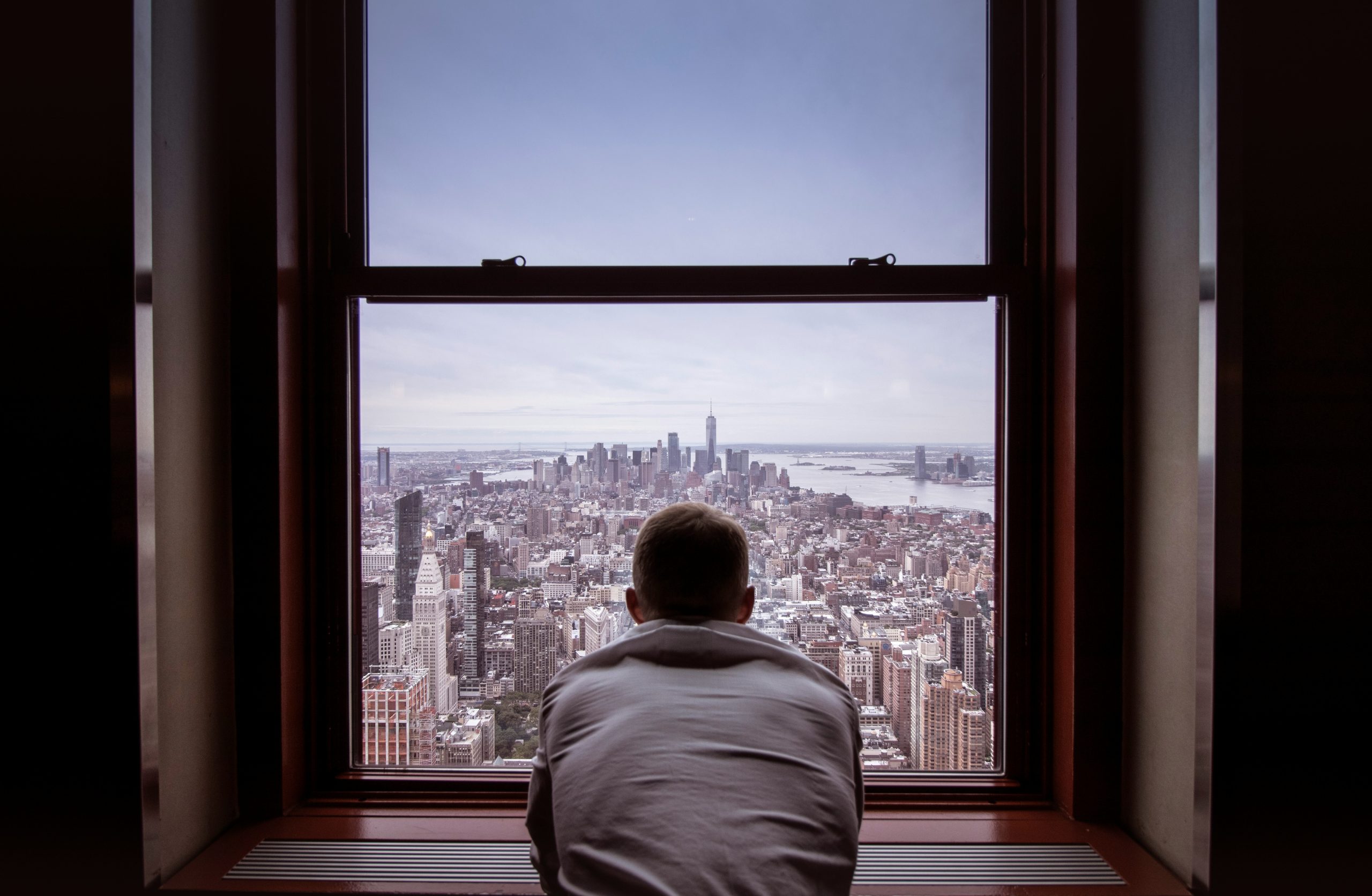 man looking out window